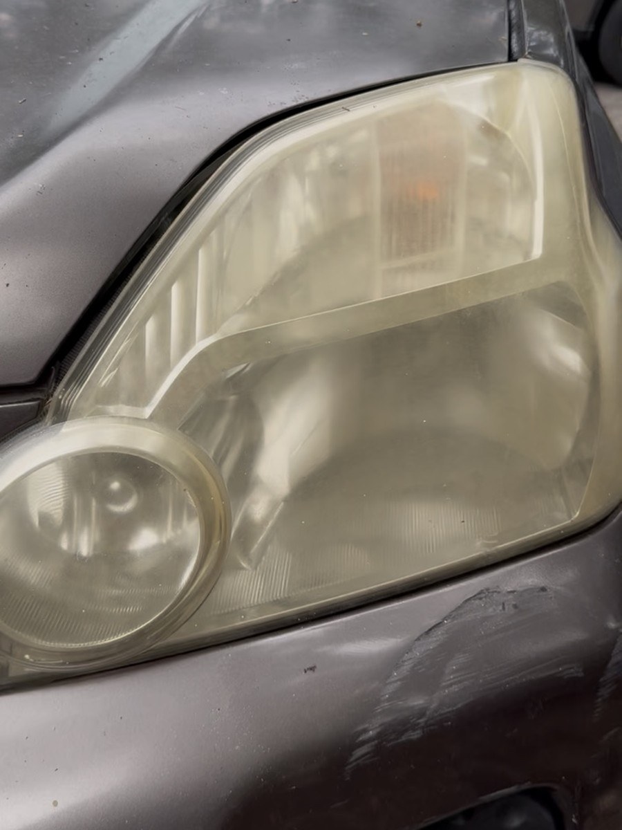 Same Nissan X-Trail headlight before restoration, cloudy and yellowed